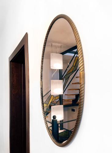 a mirror hanging on a wall with a staircase at Excelsior INN in Turda
