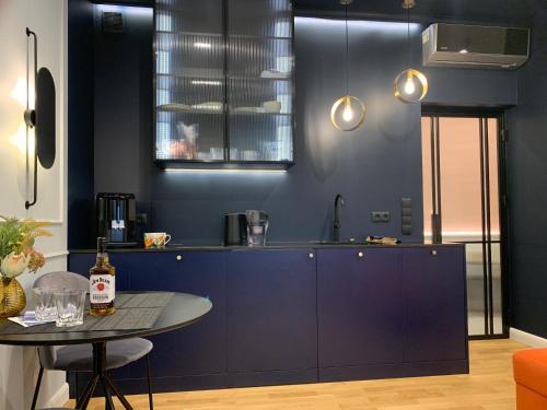 een keuken met blauwe kasten en een tafel. bij Indygo Apartment in Krakau