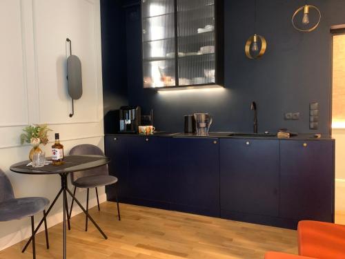 een keuken met blauwe kasten en een tafel bij Indygo Apartment in Krakau