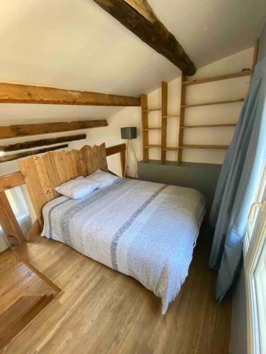 1 dormitorio con 1 cama en una habitación con suelo de madera en Maison de ville atypique, en Orange