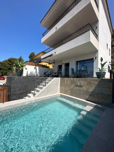 a swimming pool in front of a house at Suite en estancia maravillosa y romántica ideal parejas in Pineda de Mar