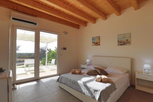 - une chambre avec un lit et une porte coulissante en verre dans l'établissement Allu ruvezzu 2.0, à Torre Mozza