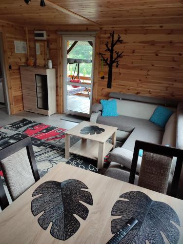 a living room with a table and chairs in a cabin at Roztocze, Domek Na Leśnym Wzgórzu nr2,Krasnobród,Zamość, Zwierzyniec, jacuzzi in AdamÃ³w