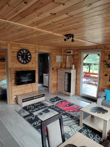 a living room with a clock on a wooden wall at Roztocze, Domek Na Leśnym Wzgórzu nr2,Krasnobród,Zamość, Zwierzyniec, jacuzzi in AdamÃ³w