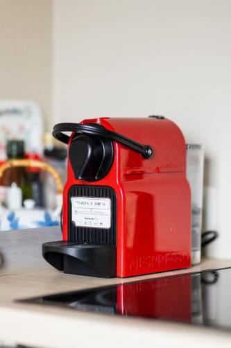 a red toaster sitting on top of a counter at Le Petit Chapitre : Maison de charme in Fosses-La-Ville
