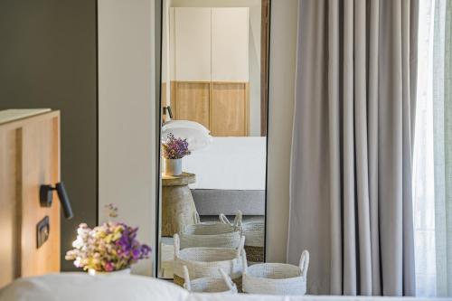 een spiegel in een kamer met stoelen en een tafel bij Achatis Suites in Chersonissos
