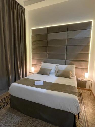 a bedroom with a large bed with a large headboard at Caracciolo18 - GB in Naples