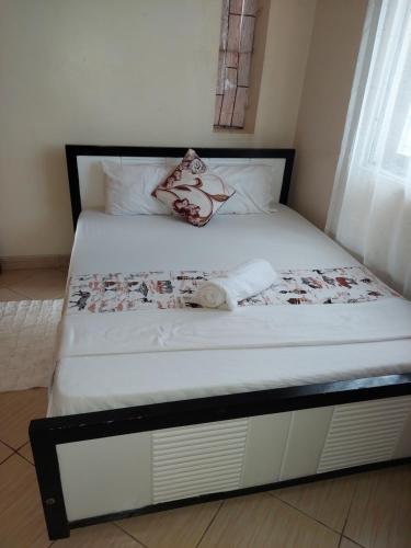 a bed with a black and white bed frame at loita apartment in Mombasa