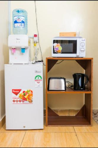 a microwave and a refrigerator next to a shelf at loita apartment in Mombasa