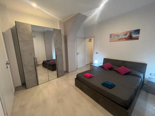 una camera da letto con un letto con cuscini rossi e uno specchio di Guest House Villanova a Cagliari