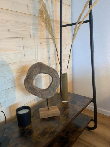 a metal sculpture on a wooden table with a vase at Staufen Herz NETFLIX WLAN in Oberstaufen