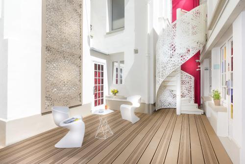 Habitación con muebles blancos y paredes rojas y blancas. en Hotel Eiffel Segur en París