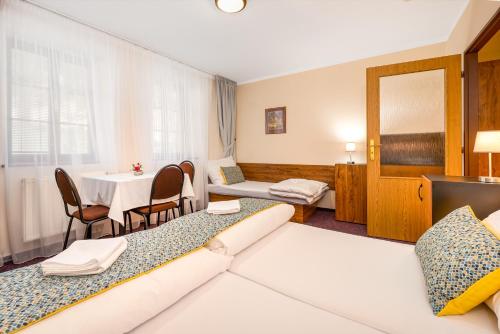 a hotel room with two beds and a table at Penzion a kemp Koruna in Zlatá Koruna