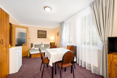a room with a table and chairs and a bed at Penzion a kemp Koruna in Zlatá Koruna