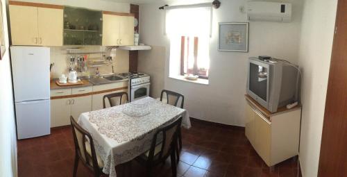 a small kitchen with a table and a television at Augustinovi Dvori in Škrip