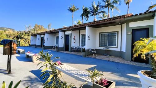 a row of buildings with palm trees in the background at Chalés Vila da Serra in Serra Negra