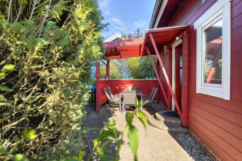 una casa roja con una mesa y sillas en un patio en Zinnowitz, Haus Jörn, en Zinnowitz