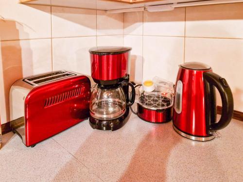 two red appliances sitting on a counter next to a toaster at Zinnowitz, Haus Jörn in Zinnowitz
