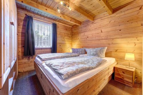 a bedroom with a bed in a log cabin at Zinnowitz, Haus Jörn in Zinnowitz