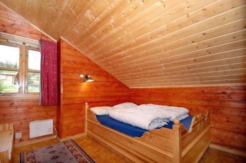 Trollbo ved Solstua في Lifjell: غرفة بسرير في كابينة خشبية