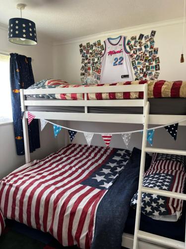 a bedroom with two bunk beds with a baseball jersey at American Retro Chalet in Hemsby