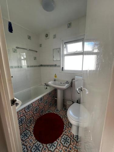 uma casa de banho com um WC, um lavatório e uma banheira em American Retro Chalet em Hemsby