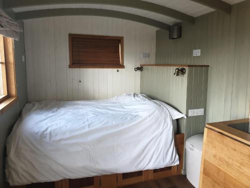 ブロードフォードにあるShepherd Huts at Corryの小さなベッドルーム(白いベッド1台、トイレ付)