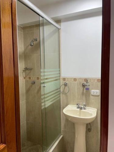 ein Bad mit einem Waschbecken und einer Glasdusche in der Unterkunft Hermoso minidepartamento in Huaraz