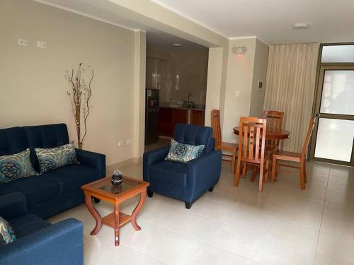 ein Wohnzimmer mit 2 blauen Sofas und einem Tisch in der Unterkunft Hermoso minidepartamento in Huaraz
