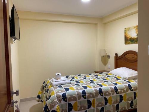 ein Schlafzimmer mit einem Bett mit einer bunten Bettdecke in der Unterkunft Hermoso minidepartamento in Huaraz