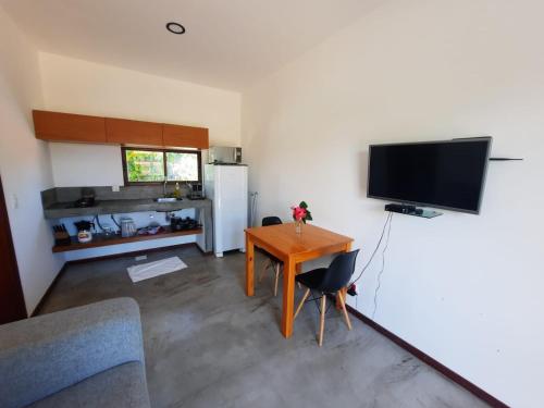 a living room with a table and a television at Agapanthus Apartamentos in Jericoacoara