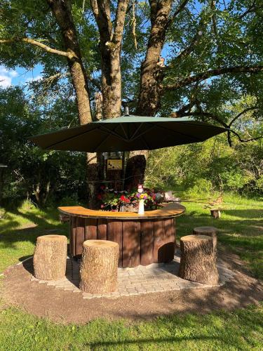 a picnic table with a large umbrella in a park at Upmaļi in Tērvete
