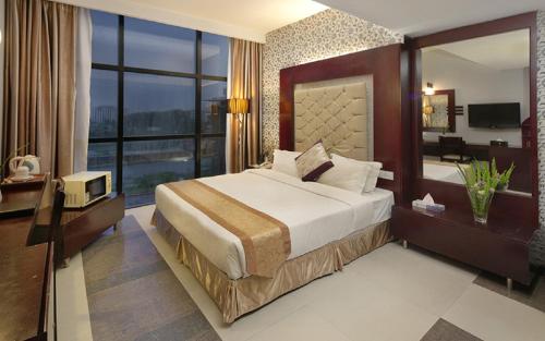ein Hotelzimmer mit einem Bett und einem großen Fenster in der Unterkunft Hotel The Cox Today in Cox's Bazar