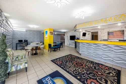 a lobby of a restaurant with tables and chairs at Days Inn & Suites by Wyndham Fort Bragg/Cross Creek Mall in Fayetteville