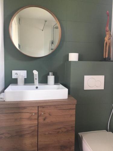 ein Badezimmer mit einem weißen Waschbecken und einem Spiegel in der Unterkunft Domek nad Bugiem z sauną 