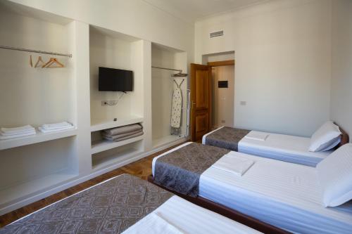 a hotel room with two beds and a tv at Le Due Piazze in Genova