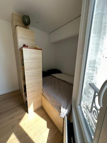 une petite chambre avec un lit et une fenêtre dans l'établissement Studio au calme à deux pas du sacré coeur, à Paris