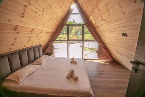 a bedroom with a bed with two teddy bears on it at Shaori Lake Cottages in Kharistʼvala