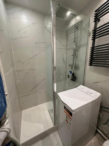 une salle de bain blanche avec une douche et un lavabo dans l'établissement Studio au calme à deux pas du sacré coeur, à Paris