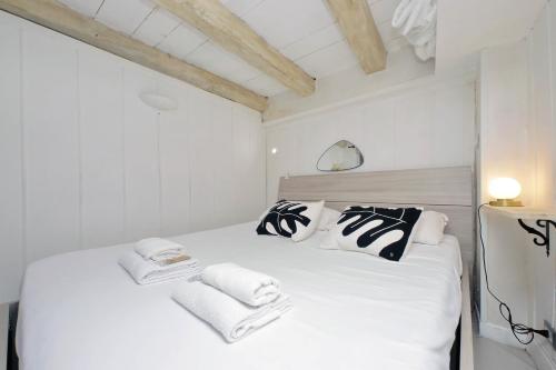 ein Schlafzimmer mit einem weißen Bett und schwarzen und weißen Handtüchern in der Unterkunft Al moretto in Rom