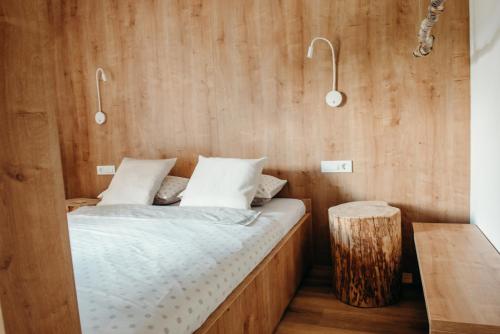 a bedroom with a bed and a wooden wall at Apartments Triglav in Mojstrana