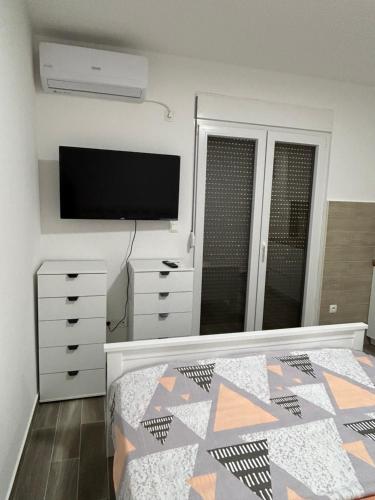 1 dormitorio con 1 cama y TV de pantalla plana en NNL Apartments, en Bar