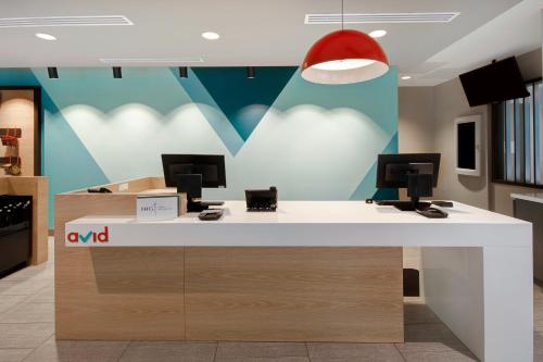 an office with a desk with two computer monitors on it at avid Hotel Fort Mill - Carowinds Blvd by IHG in Fort Mill