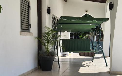 a green chair under a green umbrella on a patio at Luxuriant Houses Kyrenia in Kérynia