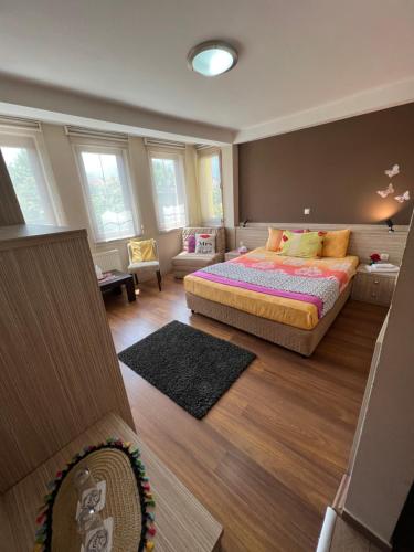 a bedroom with a bed and a living room at Hotel Bulevar in Bitola