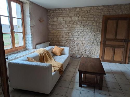 un salon avec un canapé et une table dans l'établissement Maison du parc, à Bouconville-sur-Madt