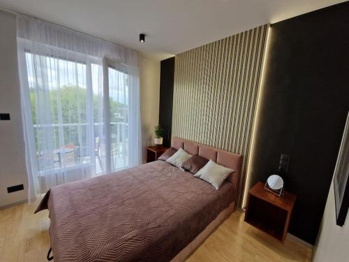 um quarto com uma cama e uma grande janela em Apartament Koral - Kompozytorów Polskich 7 em Lublin