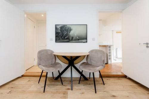 una sala da pranzo con tavolo e 2 sedie di Well-Positioned Studio Flat a Londra