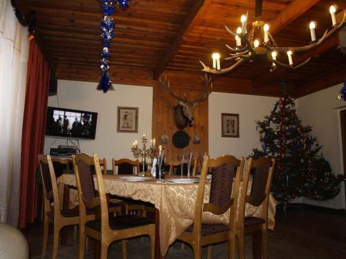 uma sala de jantar com uma mesa e uma árvore de Natal em Upmaļi em Tērvete