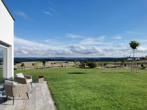 a patio with two chairs and a field of grass at Relax V Kraji in Žernov